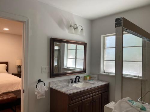 een badkamer met een wastafel, een spiegel en een bed bij Miracle Springs Resort and Spa in Desert Hot Springs