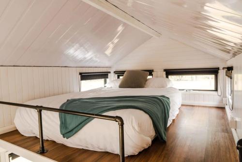 a bed in the middle of a room in a trailer at Odyssean Tiny House in Cessnock