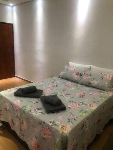 a bed with two pillows on it in a room at Confortável apartamento 2 quartos Aparecida SP in Aparecida