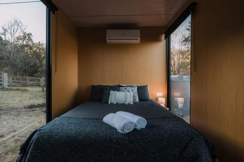Un dormitorio con una cama con una toalla. en The Wollombi Wanderer en Wollombi