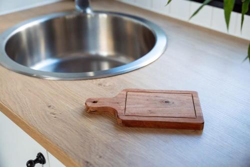a wooden block on a counter next to a sink at Kawal Tiny House in Wollombi