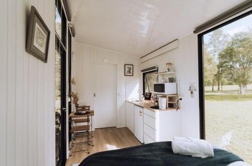 a room with a bed and a kitchen in a tiny house at Willow Dale Farm in Paterson