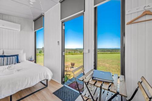 a bedroom with a bed and a large window at Valley Escape in Rothbury