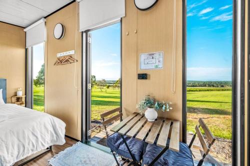 a bedroom with a bed and a table and a window at Vine View Escape in Rothbury