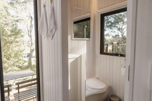 La salle de bains est pourvue de toilettes et d'une fenêtre. dans l'établissement Sunset Vine at Wonganella Estate 1, à Bobs Farm
