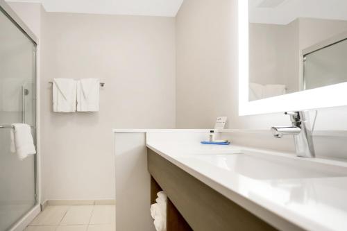 a white bathroom with a sink and a mirror at Holiday Inn Express - Jacksonville South Bartram Prk by IHG in Jacksonville