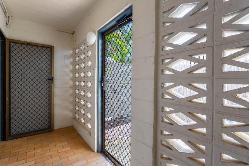 a pivot door in a wall with a window at Driftwood on the Beach in Yeppoon