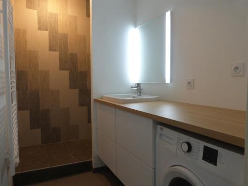 uma casa de banho com um lavatório e uma máquina de lavar roupa em Appartement La Tranche-sur-Mer, 3 pièces, 6 personnes - FR-1-194-227 em La Tranche-sur-Mer