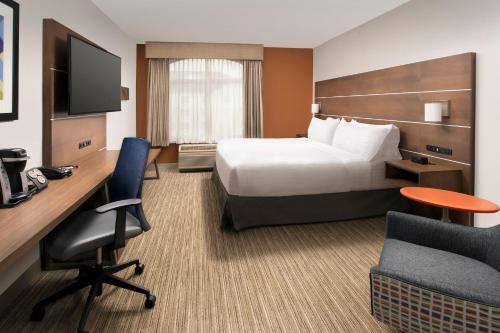 a hotel room with a bed and a desk and chair at Holiday Inn Express & Suites Baltimore - BWI Airport North, an IHG Hotel in Linthicum Heights