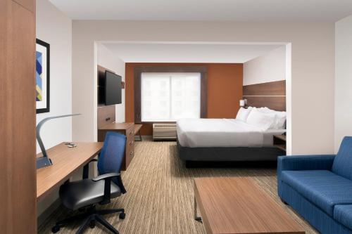 a hotel room with a bed and a desk and chair at Holiday Inn Express & Suites Baltimore - BWI Airport North by IHG in Linthicum Heights