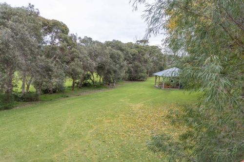 a large grass field with a gazebo in the distance at Spring Bay Villas, Denmark, WA in Denmark