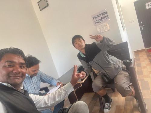a group of men sitting in a room with a man on a chair at Indiana home stay in Khajurāho