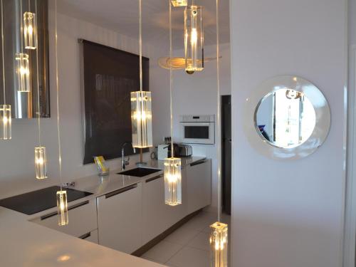 uma cozinha com um lavatório, um espelho e luzes em Apartamento L'Estartit, 3 dormitorios, 6 personas - ES-323-68 em L'Estartit