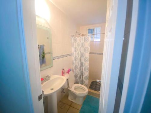 a bathroom with a white toilet and a sink at Casa Vacacional con Encanto in Penonomé