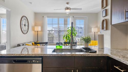 a kitchen with a sink and a living room at Stylish 2BR Corporate Stay Pool Balcony #2 in Tampa