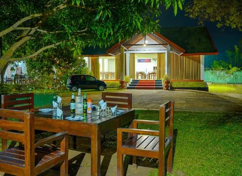 a table and chairs in a yard with a building at Elegant Riverside Resort in Dematapelessa