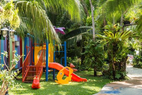 a playground with a slide in the grass at MATCHA SAMUI RESORT formerly Chaba Samui Resort in Chaweng