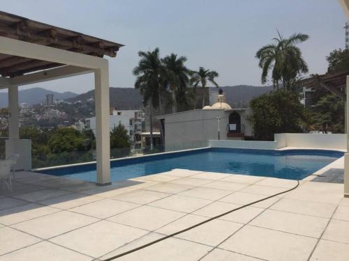 a swimming pool on the side of a house at Cómodo departamento en Costa Azul. in Acapulco