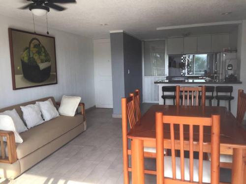 a living room and kitchen with a couch and a table at Cómodo departamento en Costa Azul. in Acapulco