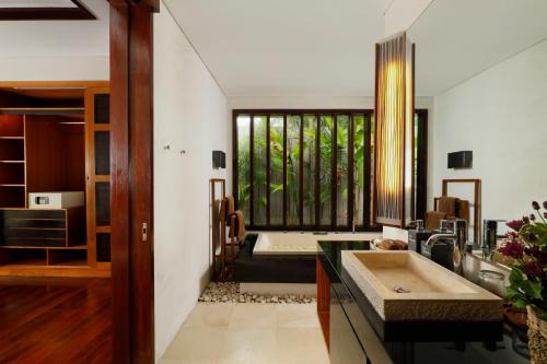 ein Badezimmer mit einem Waschbecken und einer Badewanne in der Unterkunft Villa Camellia by Nakula in Jimbaran