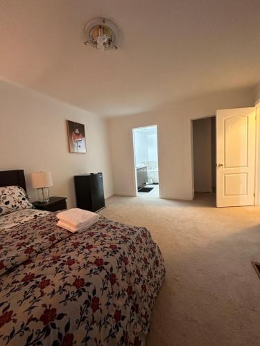 1 dormitorio con 1 cama y puerta a un balcón en Bellhaven Beautiful Home, en Brampton