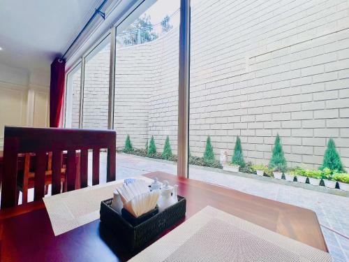 a dining room table with a chair and a large window at CALYSSA HOTELS & VILLAGE in Khu Chi Lăng