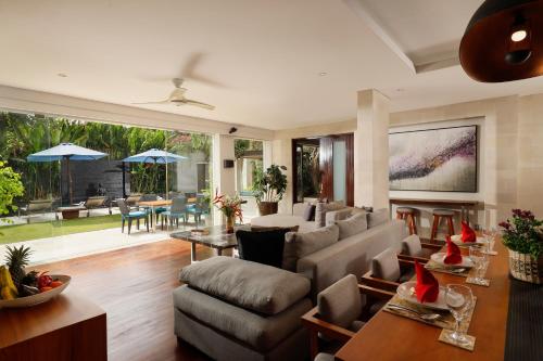 ein Wohnzimmer mit einer Couch und einem Tisch in der Unterkunft Villa Camellia by Nakula in Jimbaran