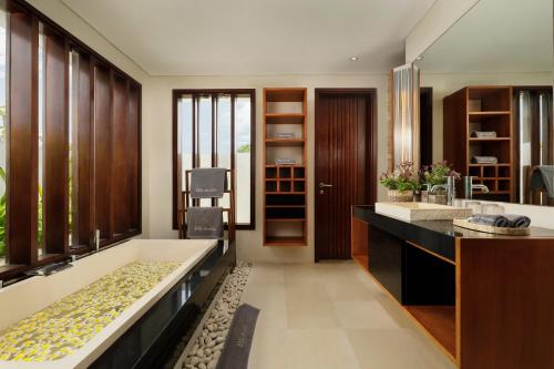 a bathroom with a large tub and a sink at Villa Camellia by Nakula in Jimbaran