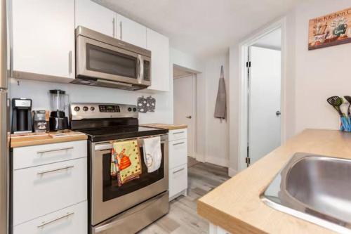 a kitchen with a stove and a microwave at Cozy Furnished Room in Edmonton - Close to U of A in Edmonton