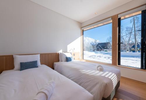 two beds in a room with a window at Ro-An in Niseko