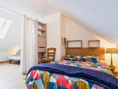 ein Schlafzimmer mit einem farbenfrohen Bett und einem Stuhl in der Unterkunft Gîte Assérac, 2 pièces, 4 personnes - FR-1-306-1268 in Assérac