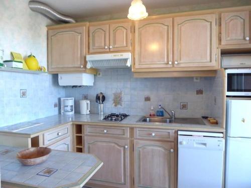 - une cuisine avec des placards en bois et des appareils blancs dans l'établissement Appartement 2 pièces + cabine, 6 pers., proche plage, garage, animaux bienvenus - FR-1-776-84, à Argelès-sur-Mer