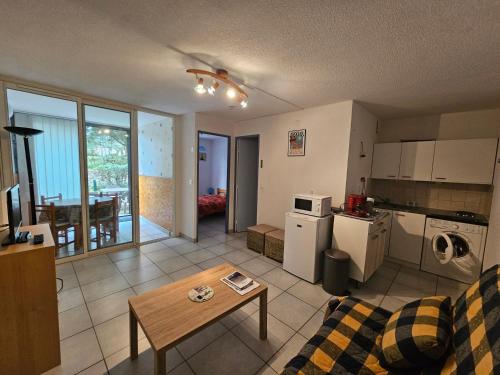 un salon avec un canapé et une table dans l'établissement Appartement T2 en Rez-de-Jardin, Terrasse, à 300m de la Plage, Parking, Environnement Calme et Boisé - FR-1-550-71, à Saint-Georges-de-Didonne