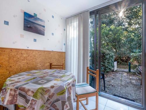 une chambre avec un lit et une grande fenêtre dans l'établissement Appartement T2 en Rez-de-Jardin, Terrasse, à 300m de la Plage, Parking, Environnement Calme et Boisé - FR-1-550-71, à Saint-Georges-de-Didonne