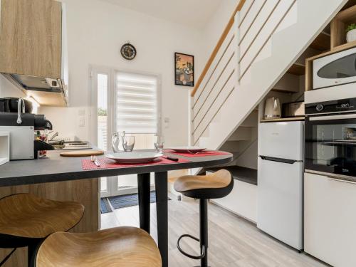 une cuisine avec un comptoir, une table et des chaises dans l'établissement Charmant gîte indépendant avec terrasse, proche plage et golf, idéal pour des vacances à Pornic - FR-1-306-1267, à Pornic