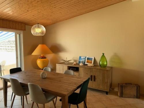 une salle à manger avec une table et des chaises en bois dans l'établissement Maison 3 chambres au calme, 3* - Proche plage et commerces, WiFi, terrasse, jardin, TV box, garage - FR-1-323-525, à Saint-Jean-de-Monts