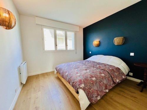 une chambre avec un lit avec un mur bleu dans l'établissement Appartement lumineux refait à neuf, centre-ville, proche plage, balcon sud, parking, WIFI - FR-1-478-271, à Quiberon