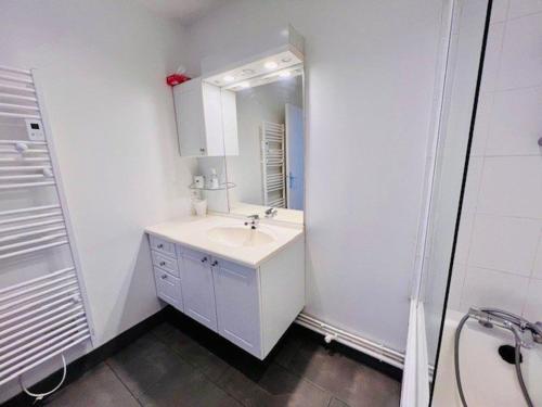 une salle de bain blanche avec un lavabo et un miroir dans l'établissement Appartement lumineux refait à neuf, centre-ville, proche plage, balcon sud, parking, WIFI - FR-1-478-271, à Quiberon