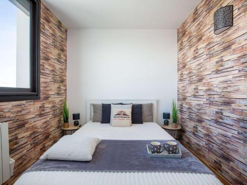 une chambre avec un lit et un mur de briques dans l'établissement Superbe Appartement Familial en Pieds de Pistes à Saint-Lary-Soulan - FR-1-296-496, à Saint-Lary-Soulan