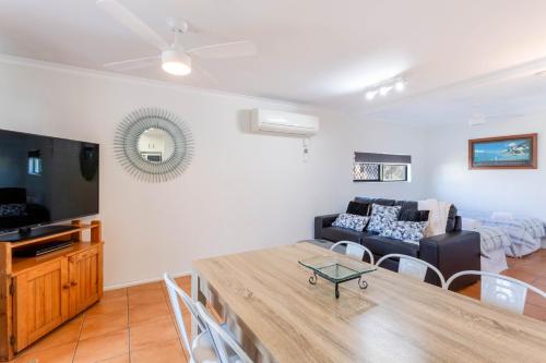 a living room with a couch and a table at Driftwood on the Beach in Yeppoon