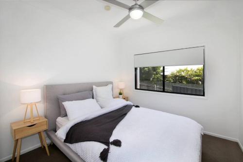 1 dormitorio con 1 cama y ventilador de techo en Alex Heads Beach Haven, en Alexandra Headland