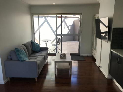 a living room with a couch and a table at Tranquil & luxurious retreat in Grays Point in Grays Point