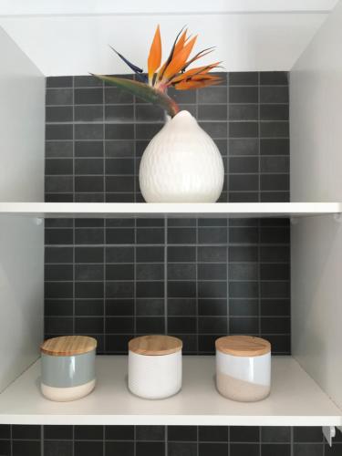a shelf with a white vase and three stools at Tranquil & luxurious retreat in Grays Point in Grays Point