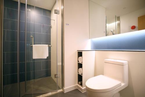 a bathroom with a toilet and a glass shower at Holiday Inn Express Chengdu North Railway Station by IHG - Near Panda Base, Near Chunxi Road in Chengdu
