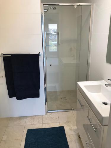 a bathroom with a shower and a black towel at Tranquil & luxurious retreat in Grays Point in Grays Point