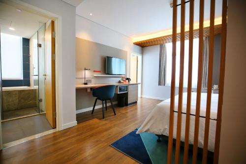 a bedroom with a bed and a desk with a chair at Holiday Inn Express Chengdu North Railway Station by IHG - Near Panda Base, Near Chunxi Road in Chengdu