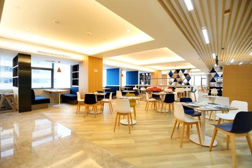 a restaurant with tables and chairs in a building at Holiday Inn Express Chengdu North Railway Station by IHG - Near Panda Base, Near Chunxi Road in Chengdu