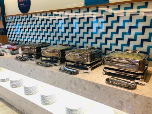 a buffet line with plates and trays of food at Holiday Inn Express Chengdu North Railway Station by IHG - Near Panda Base, Near Chunxi Road in Chengdu