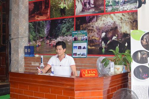 a man sitting at a counter in a restaurant at Phong Nha Backpacker Hostel in Cừ Lạc