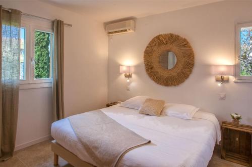 a bedroom with a bed and a mirror on the wall at Villa Albizzia with terrace and garden 68 people in Calvi